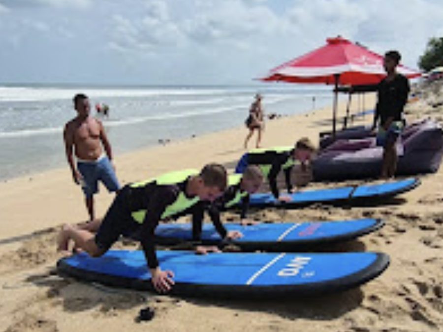 Beginners practising the pop-up on the sand at Kuta Beach